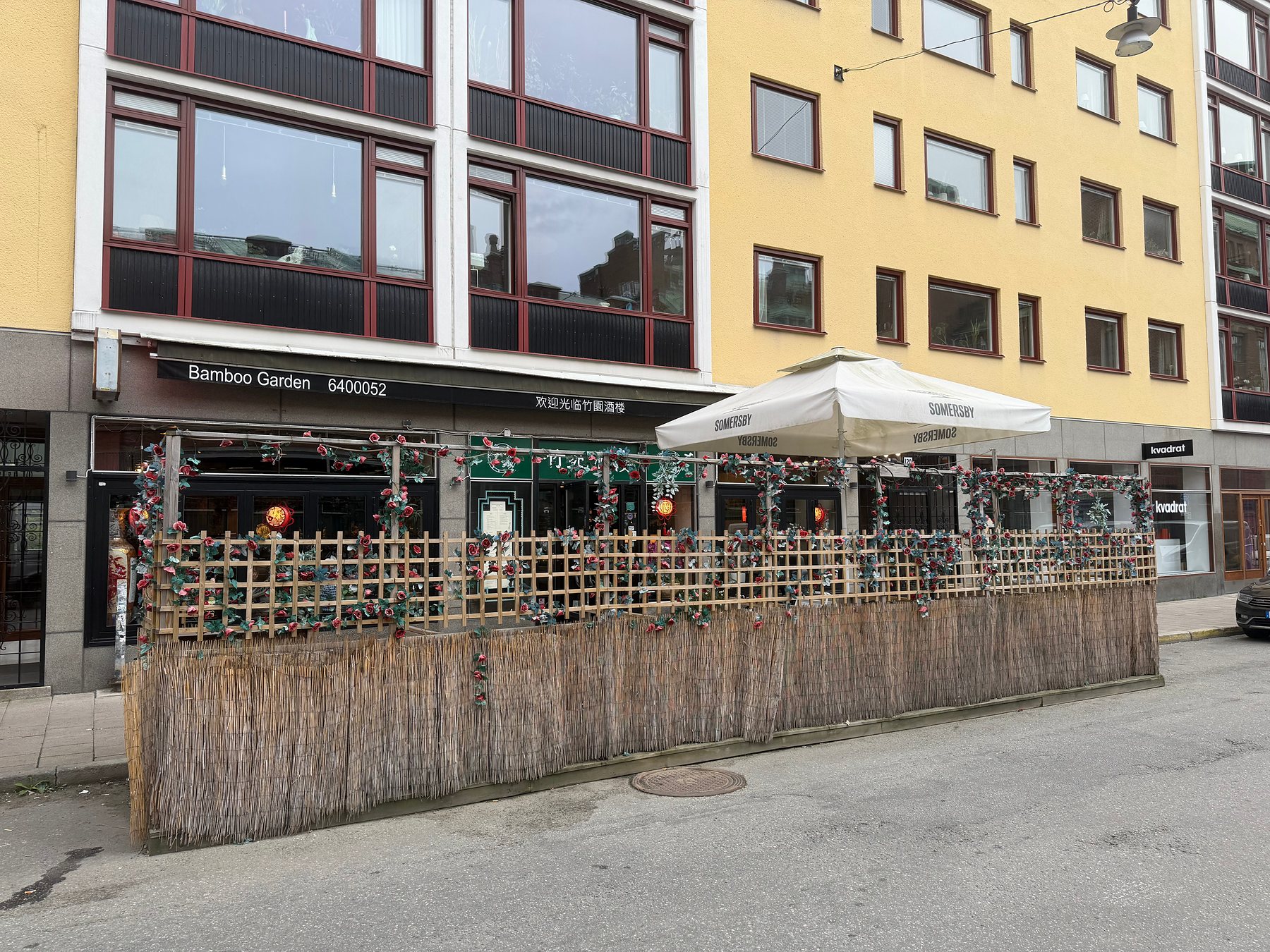 Fasaden på Åsögatan 120 med skylten Bamboo Garden och uteserveringen
