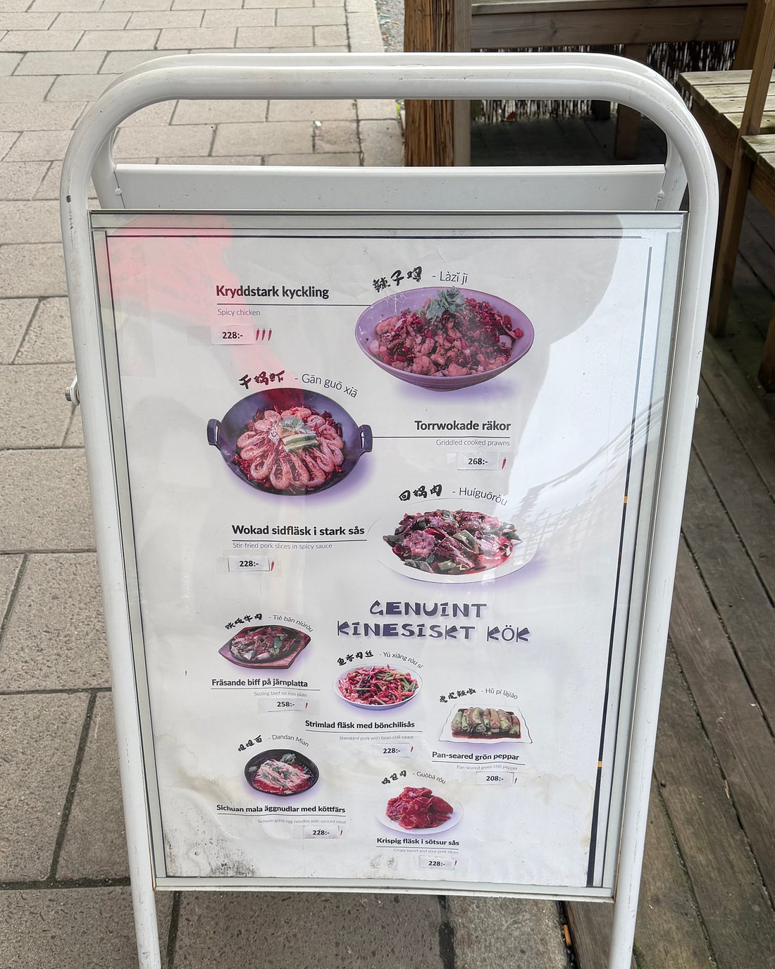 Gatuskylten Genuint kinesiskt kök på trottoaren utanför restaurangen